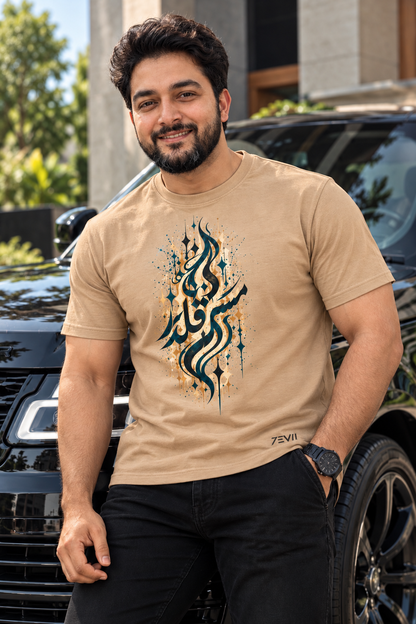 Irf wearing the 7EVII Urdu calligraphy T-shirt in Sand, front view